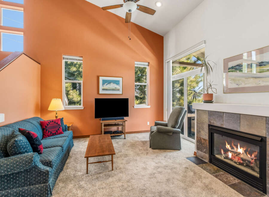 Step into this inviting living room, featuring a cozy fireplace and a comfortable seating area.