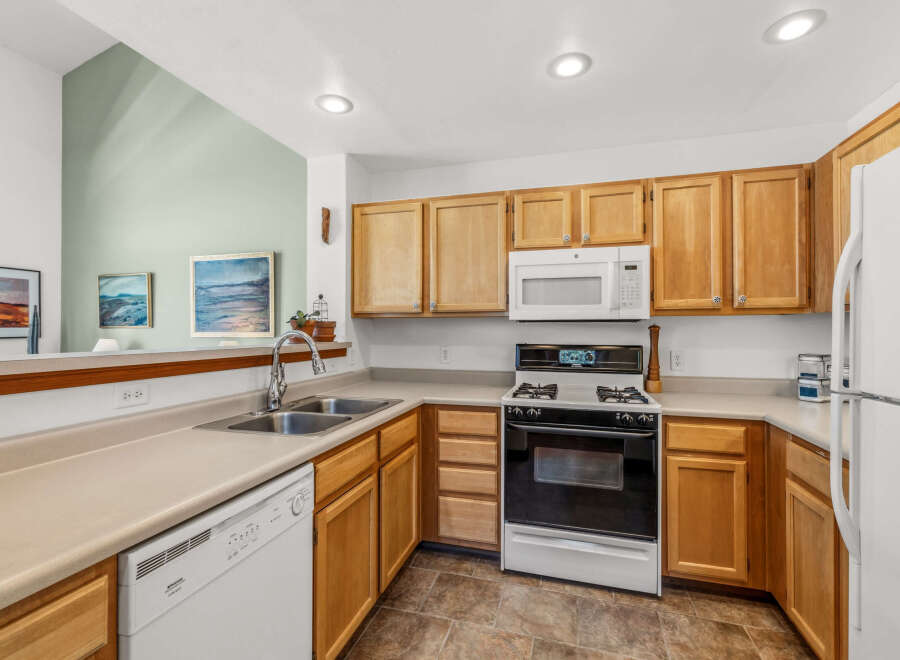 Step into this inviting kitchen, featuring warm wooden cabinetry and ample counter space.