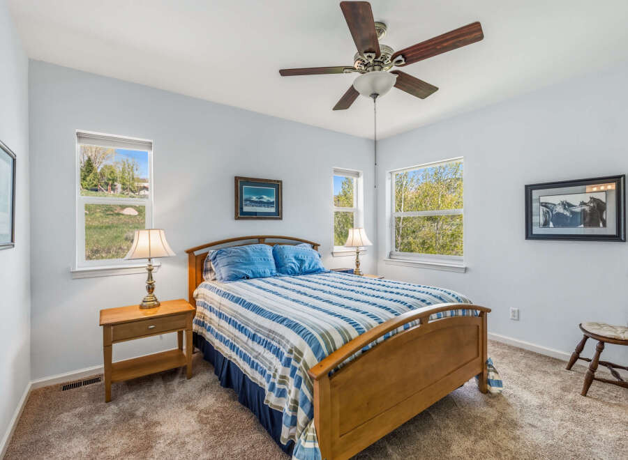 This inviting bedroom features a comfortable bed with a stylish blue and white striped comforter, perfect for a relaxing retreat.