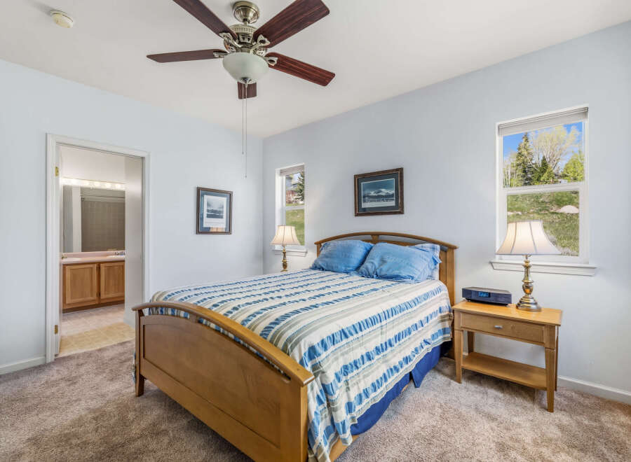 This inviting bedroom features a comfortable bed with a stylish striped comforter, perfect for a relaxing retreat.
