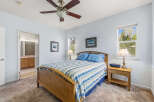 This inviting bedroom features a comfortable bed with a stylish striped comforter, perfect for a relaxing retreat.