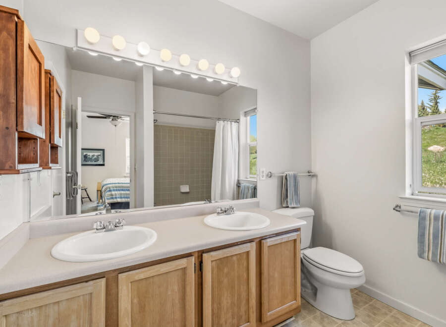 This inviting bathroom features a double vanity with ample counter space, perfect for shared use.
