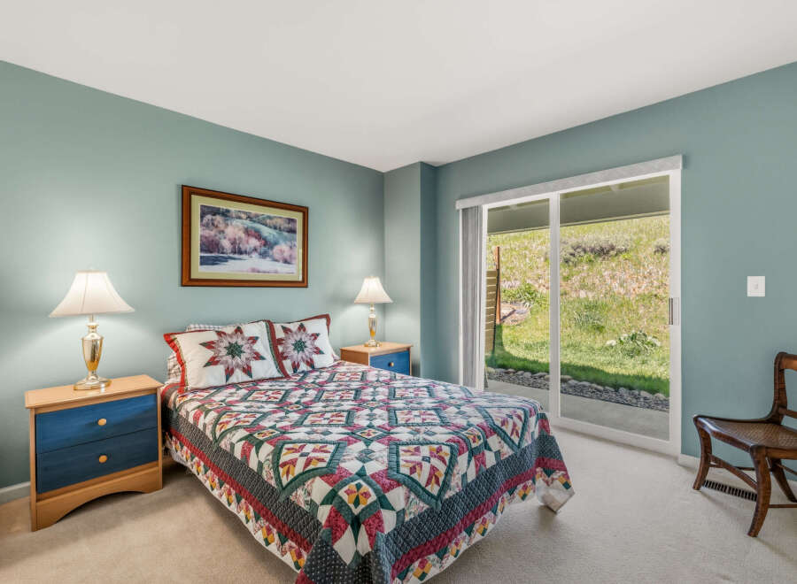This cozy bedroom features a comfortable bed adorned with a colorful quilt and matching pillows, creating a warm and inviting atmosphere.