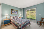 This cozy bedroom features a comfortable bed adorned with a colorful quilt and matching pillows, creating a warm and inviting atmosphere.