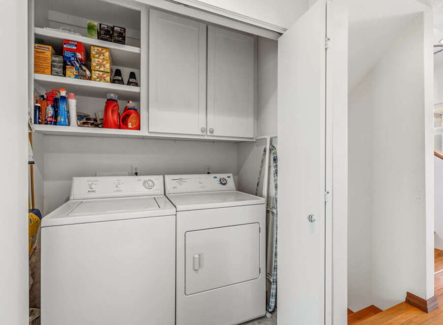 This laundry room offers convenience and functionality with its modern appliances and ample storage.