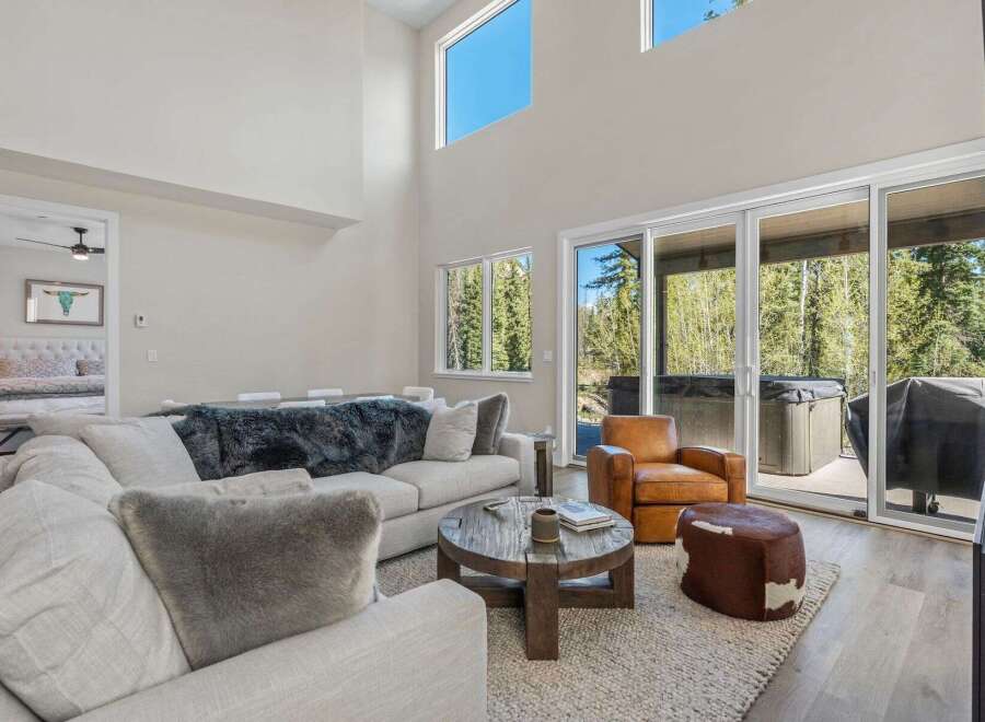 Experience luxury living in this stunning property, featuring a spacious living room with high ceilings and large windows that flood the space with natural light.
