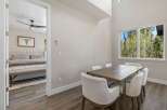 This stunning property features a modern dining area with a beautiful wooden table and comfortable white chairs, perfect for hosting guests.