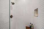 Step into a spa-like oasis with this stunning shower featuring elegant white wave-patterned tiles.