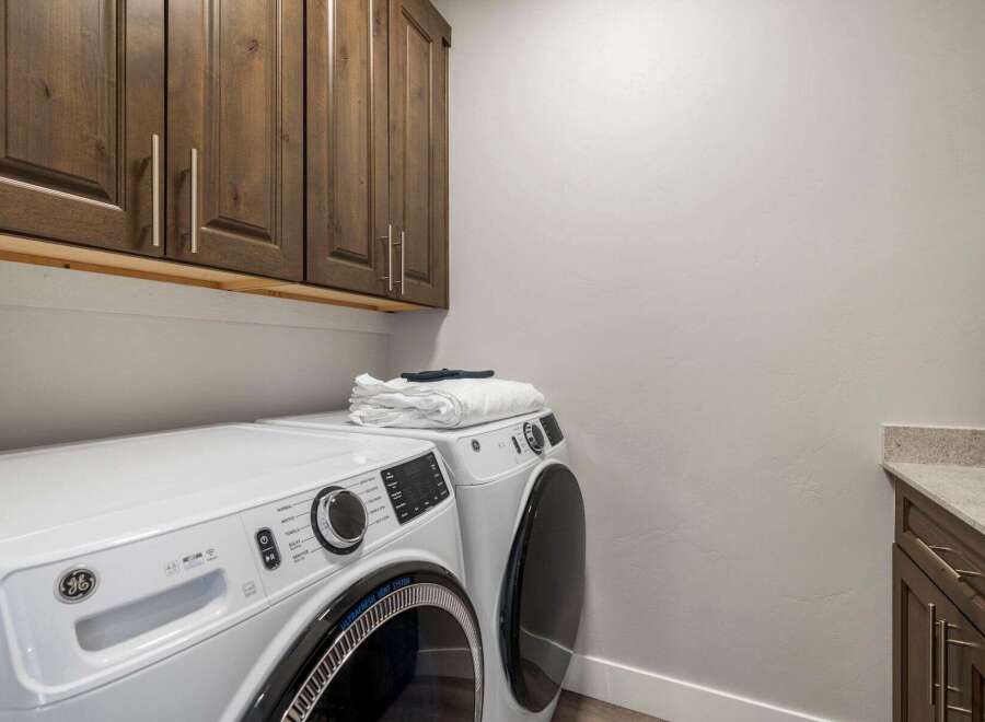 Discover the convenience of this well-appointed laundry room, featuring modern appliances and ample storage.