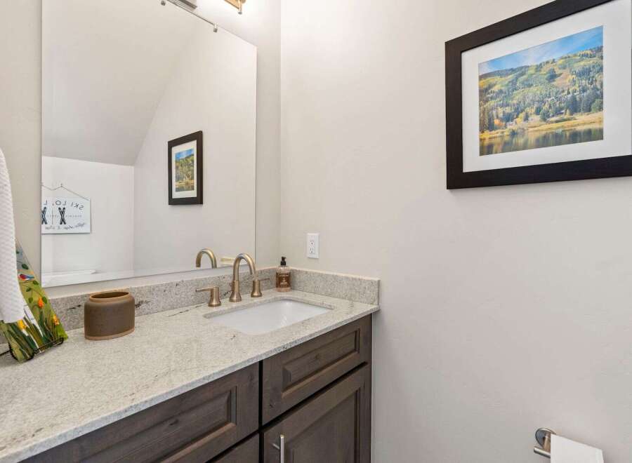 This stunning bathroom features a modern design with a sleek vanity and a beautiful granite countertop.