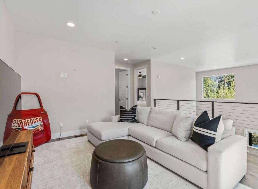 This stunning property boasts a modern living space with a comfortable sectional sofa and stylish accent pillows.