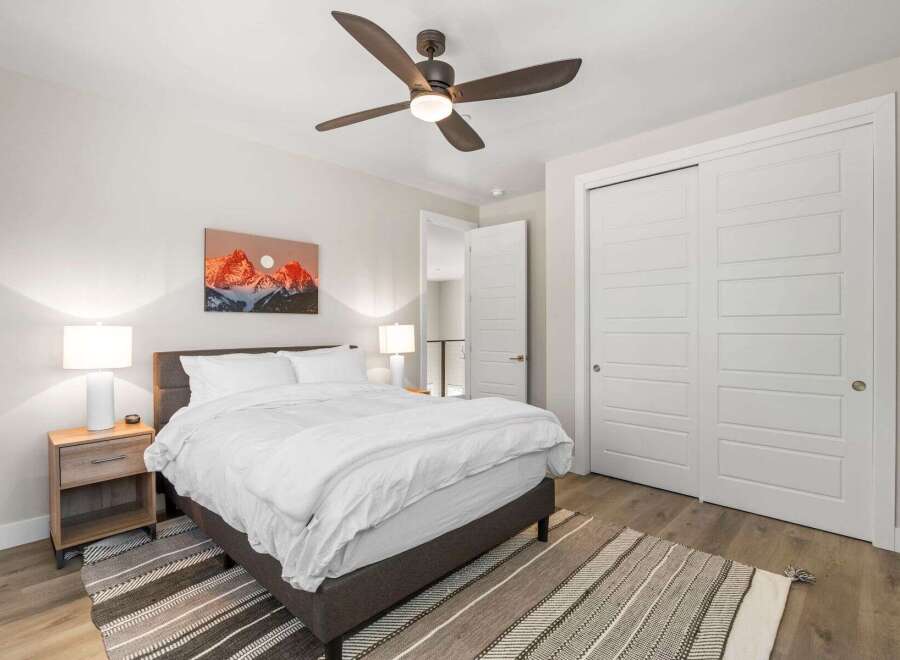 Step into this inviting bedroom, featuring a cozy bed and a stylish rug.