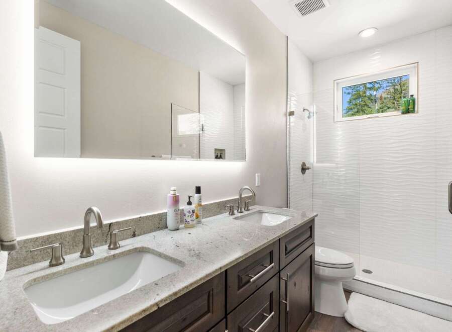 This stunning bathroom features a modern design with a double vanity, offering ample space for daily routines.