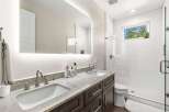 This stunning bathroom features a modern design with a double vanity, offering ample space for daily routines.