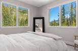 Experience the tranquility of this stunning bedroom, featuring breathtaking mountain views framed by large windows.