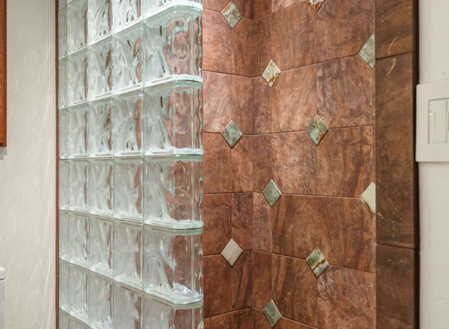 This stunning property features a unique design with glass block walls and elegant tile accents.