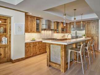 This stunning kitchen boasts custom wooden cabinetry, offering ample storage and a warm, inviting atmosphere.