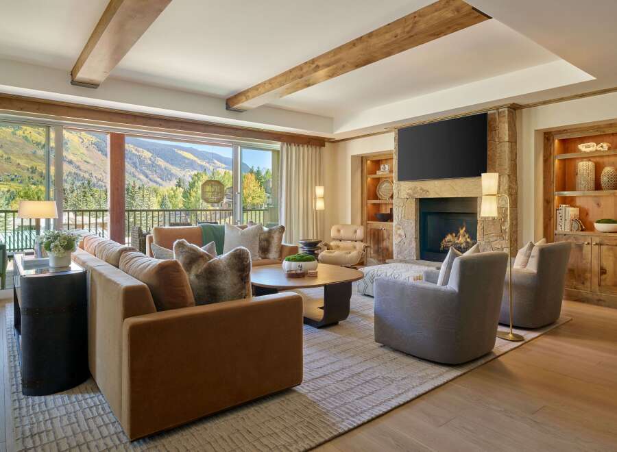 Experience luxury living in this stunning property, featuring a cozy living room with a fireplace and a breathtaking mountain view.