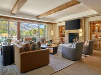 Experience luxury living in this stunning property, featuring a cozy living room with a fireplace and a breathtaking mountain view.