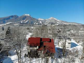 Nestled in a serene winter landscape, this property boasts a stunning red-roofed house, offering a cozy retreat.
