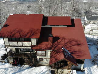 This stunning property boasts a unique architectural design with a striking red roof, perfect for those seeking a distinctive home.