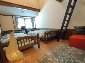 Discover a cozy retreat in this charming bedroom featuring two comfortable beds, perfect for a relaxing stay.