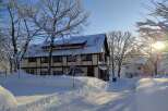 Nestled in a winter wonderland, this charming property boasts a snow-covered roof and a picturesque setting.