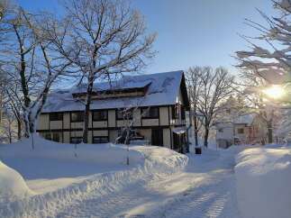 Nestled in a winter wonderland, this charming property boasts a snow-covered roof and a picturesque setting.