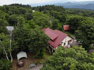 Nestled amidst lush greenery, this charming property boasts a distinctive red-roofed building, exuding a warm and inviting ambiance.