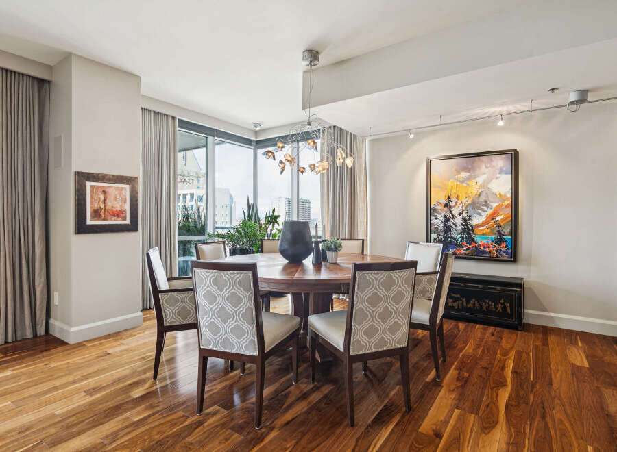 Step into luxury with this stunning dining room, featuring a beautiful round wooden table and elegant patterned chairs.