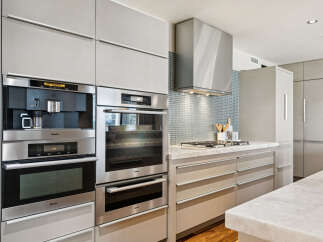 This modern kitchen boasts sleek, high-end appliances and custom cabinetry, perfect for the discerning homeowner.