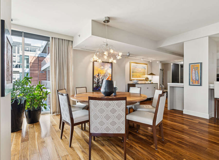 This stunning dining room features a modern design with a round wooden table and stylish chairs.