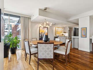 This stunning dining room features a modern design with a round wooden table and stylish chairs.