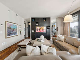 Experience luxury living in this stunning property, featuring a modern living room with a sleek entertainment center and a comfortable leather sofa.