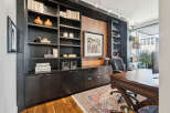 This stunning home office boasts a custom-built dark wood bookcase, providing ample storage and a sophisticated aesthetic.