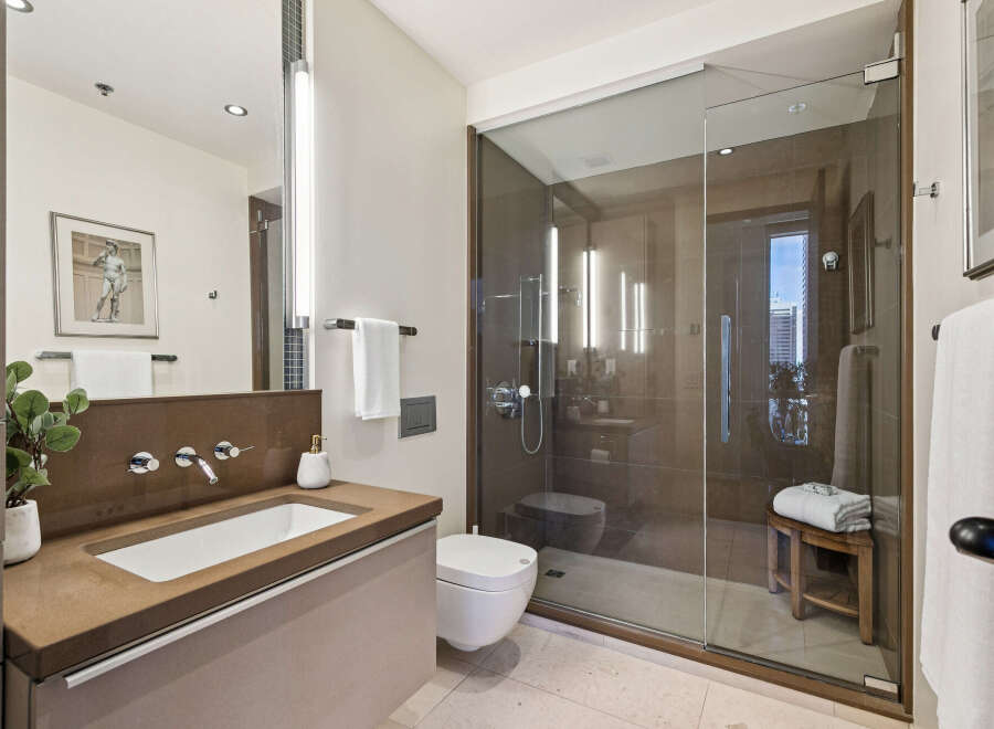 Step into luxury with this stunning bathroom, featuring a sleek glass shower and modern fixtures.