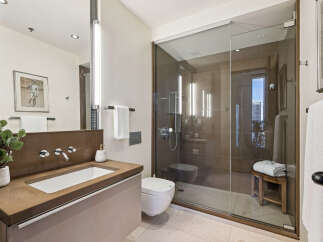 Step into luxury with this stunning bathroom, featuring a sleek glass shower and modern fixtures.