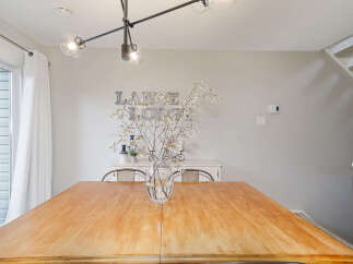 This stunning dining room features a beautiful wooden table, perfect for hosting gatherings.