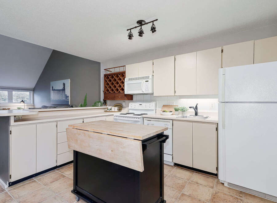 This charming kitchen boasts a functional layout with ample counter space and storage.