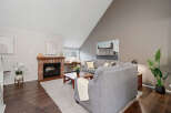 Step into this inviting living space, featuring a cozy brick fireplace and a stylish, modern design.