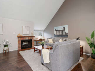Step into this inviting living space, featuring a cozy brick fireplace and a stylish, modern design.