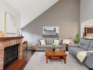 Discover the charm of this inviting living space, featuring a cozy fireplace and a stylish seating area.