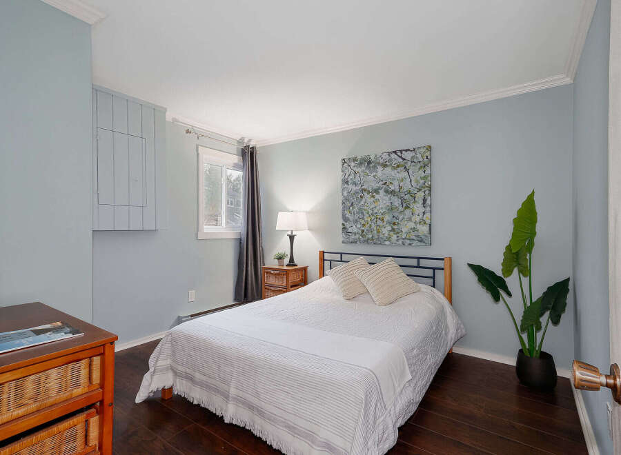 This cozy bedroom features a comfortable bed with stylish bedding, perfect for a relaxing retreat.