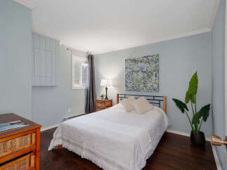 This cozy bedroom features a comfortable bed with stylish bedding, perfect for a relaxing retreat.