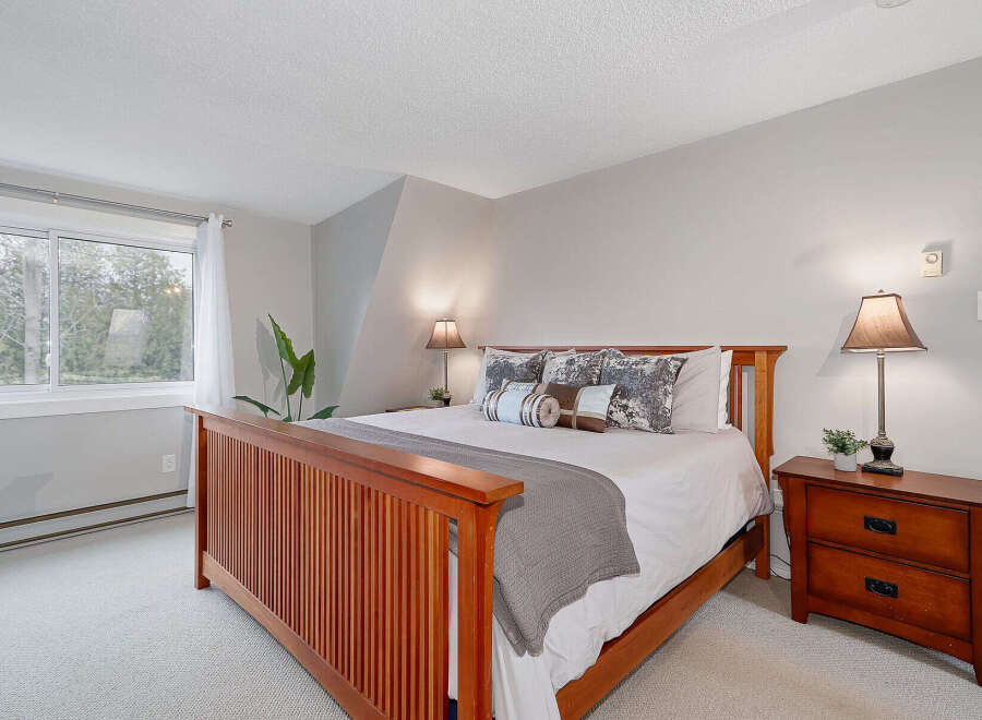 This inviting bedroom features a comfortable bed with stylish bedding and decorative pillows, creating a cozy and relaxing atmosphere.