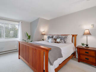 This inviting bedroom features a comfortable bed with stylish bedding and decorative pillows, creating a cozy and relaxing atmosphere.