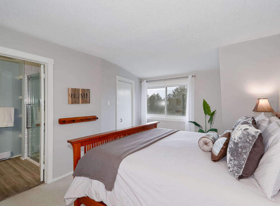 Step into this inviting bedroom, featuring a cozy bed adorned with plush pillows and a stylish throw.