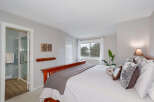 Step into this inviting bedroom, featuring a cozy bed adorned with plush pillows and a stylish throw.