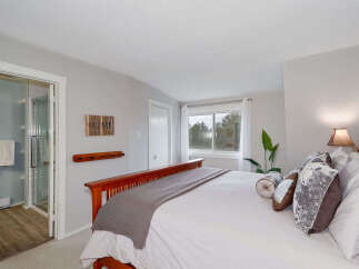 Step into this inviting bedroom, featuring a cozy bed adorned with plush pillows and a stylish throw.