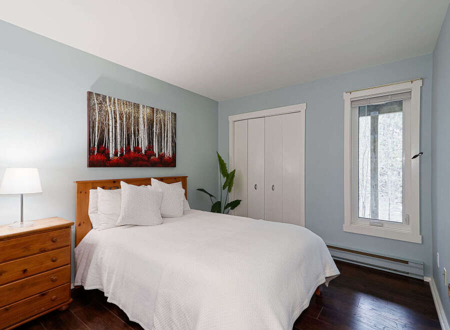 This inviting bedroom features a cozy ambiance with its soft blue walls and natural wood accents.